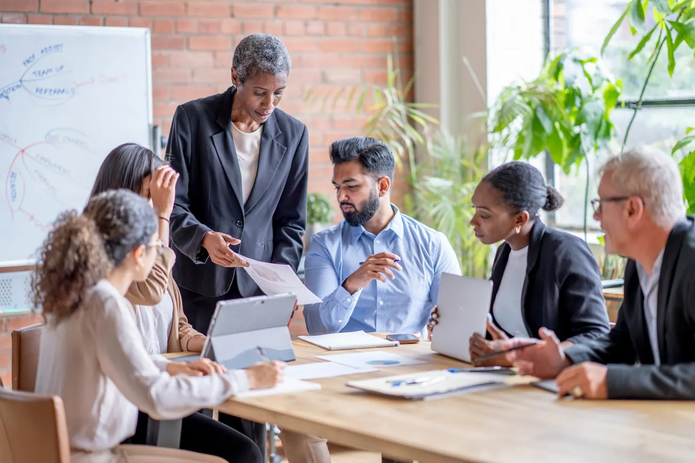 Equipe da Acertik reunida com clientes analisando documentos